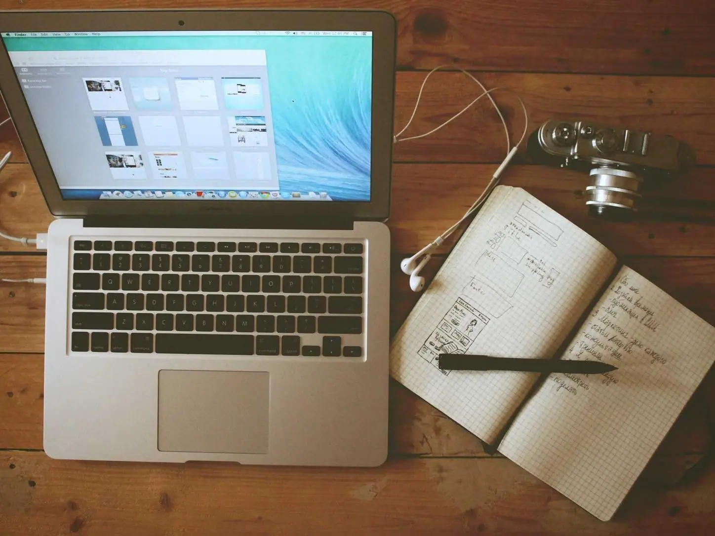 A laptop and open notebook on a desk